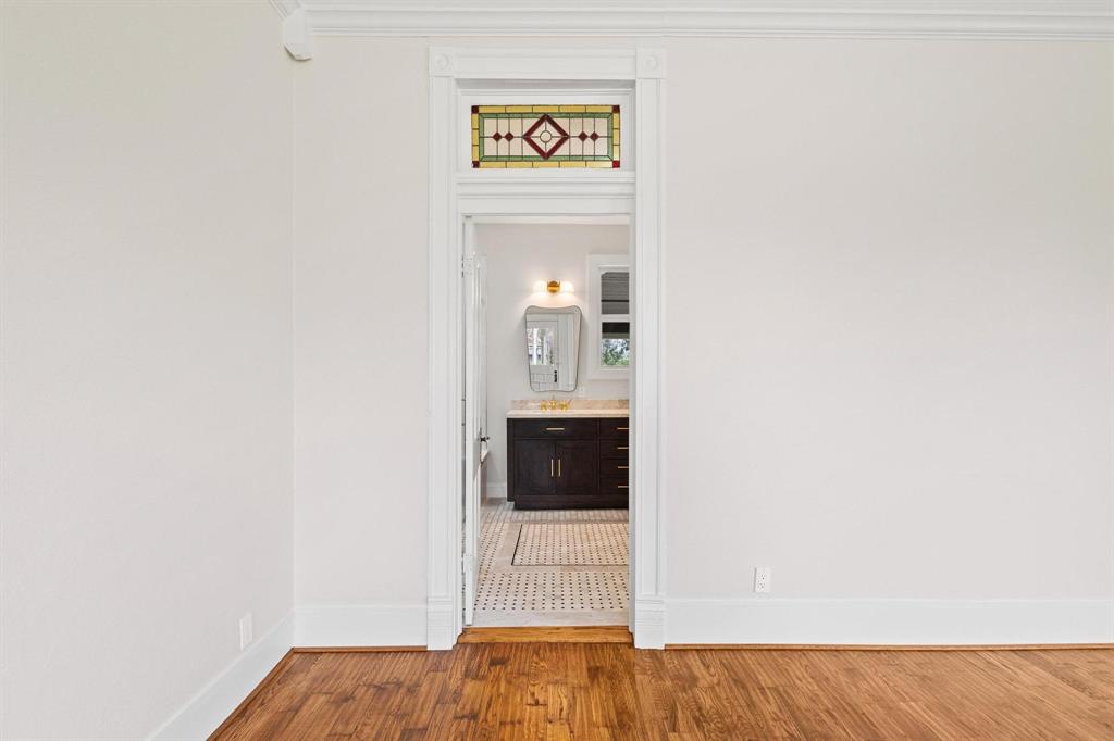 1001 West Morton Street Denison, TX 75020 - Photo 22 of 37 a view of a hallway with wooden floor and a bathroom