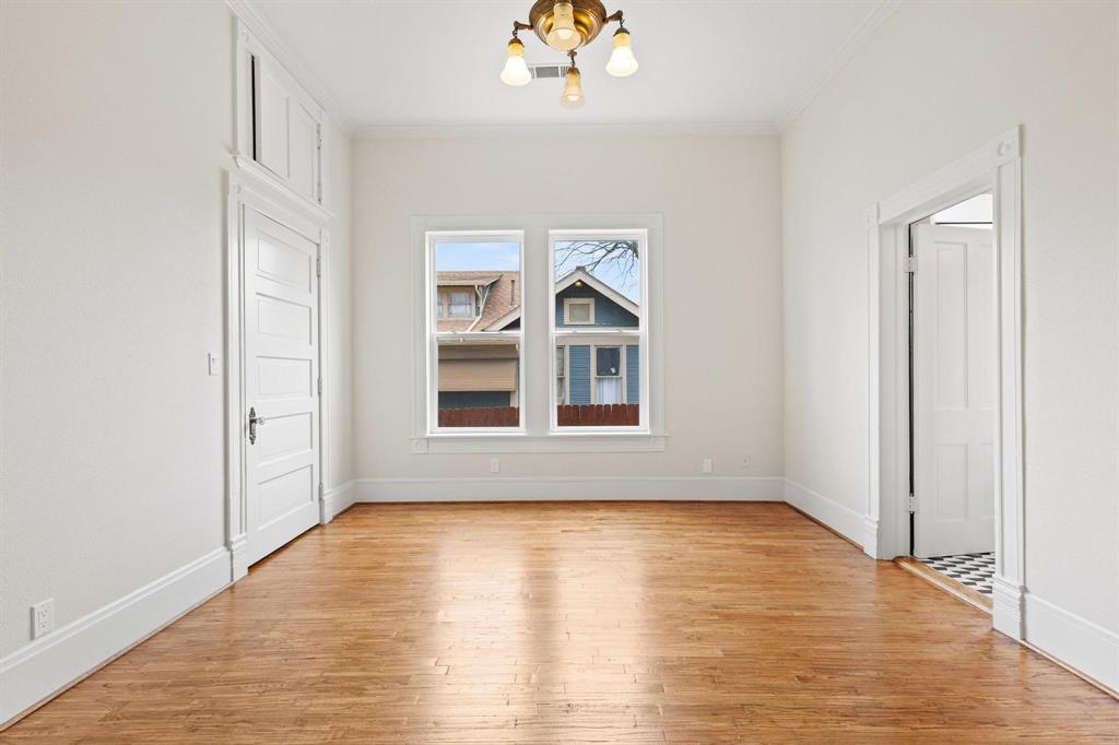 1001 West Morton Street Denison, TX 75020 - Photo 27 of 37 an empty room with wooden floor chandelier and windows