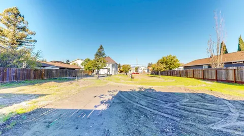 a view of swimming pool with lawn chairs and wooden fence