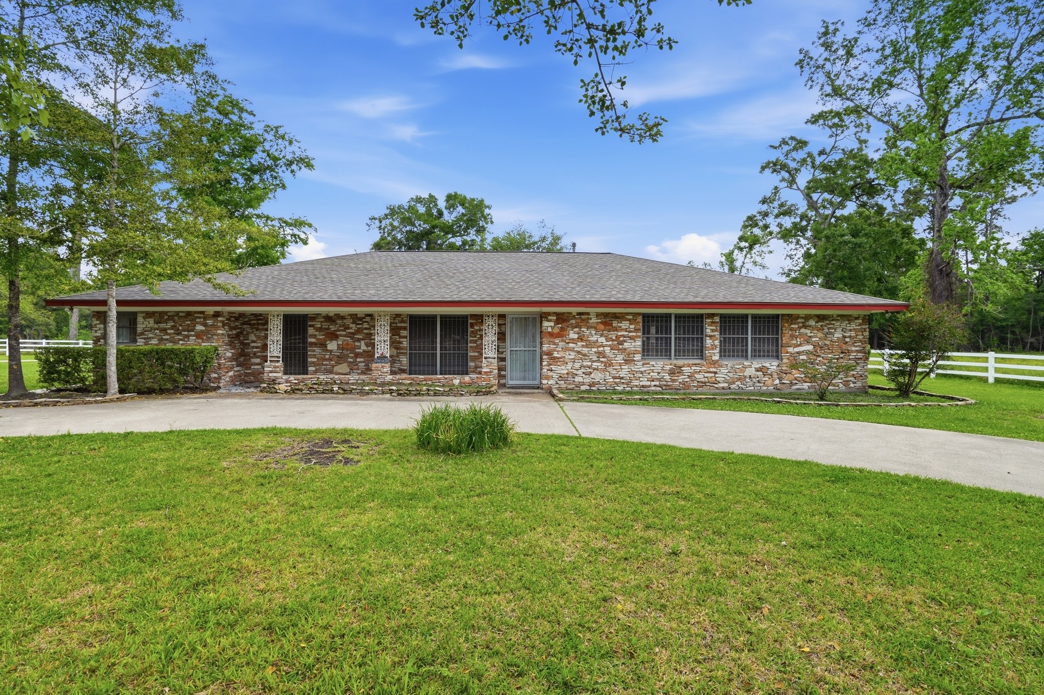10240 Post Oak Drive Conroe, TX 77385 - Photo 2 of 46 a front view of a house with a garden