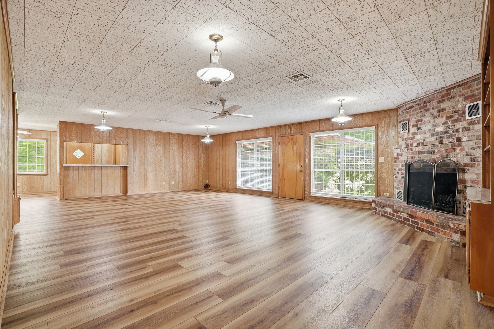 10240 Post Oak Drive Conroe, TX 77385 - Photo 21 of 46 an empty room with wooden floor fireplace and windows