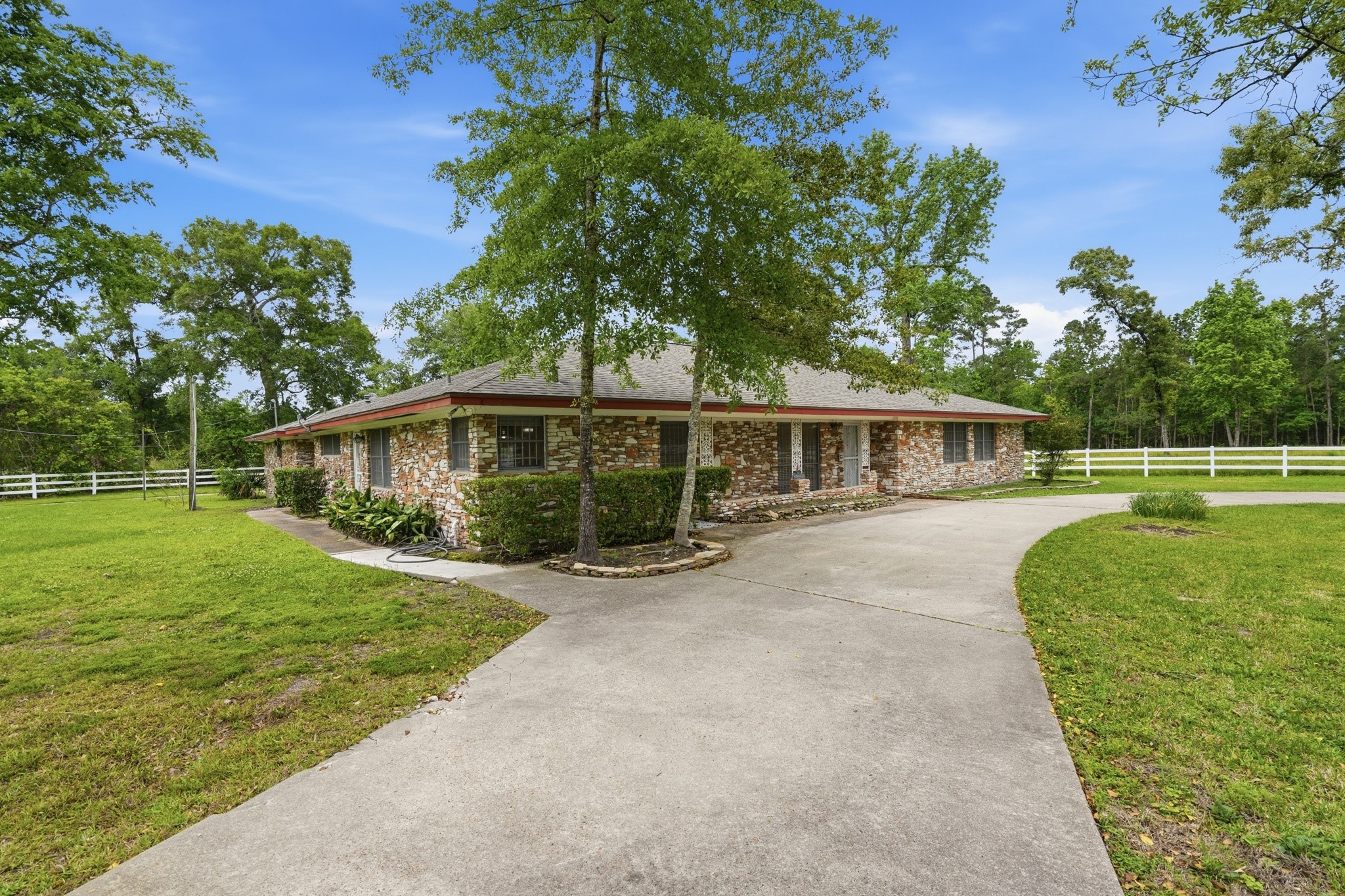 10240 Post Oak Drive Conroe, TX 77385 - Photo 3 of 46 a front view of a house with a garden