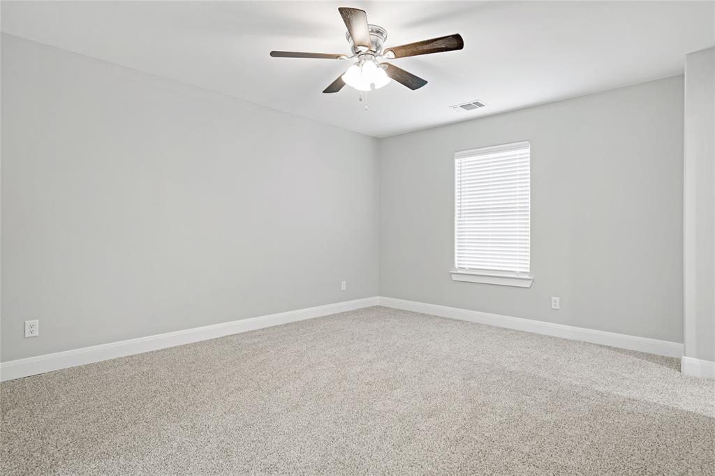 526 West Elm Street Denison, TX 75020 - Photo 12 of 17 Spare room with light carpet and ceiling fan