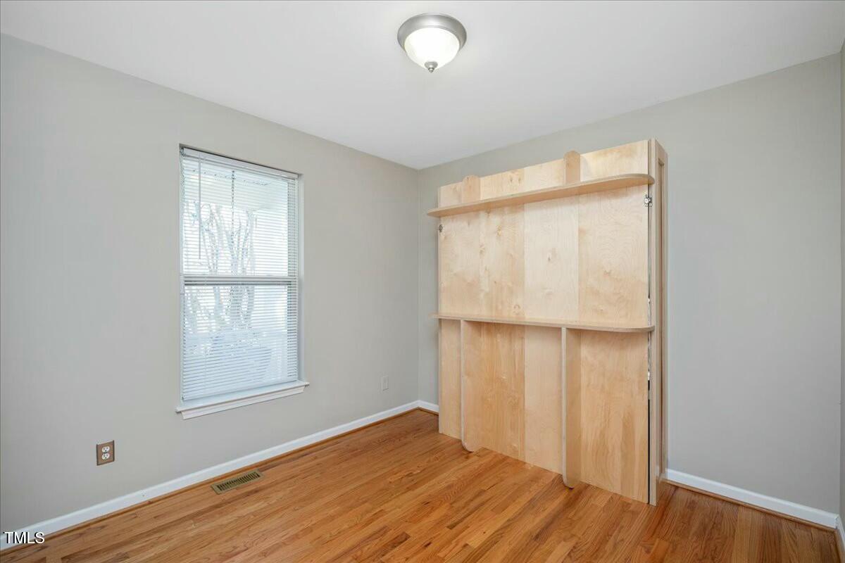 552 Moseley Lane Raleigh, NC 27601 - Photo 8 of 25 an empty room with wooden floor and windows