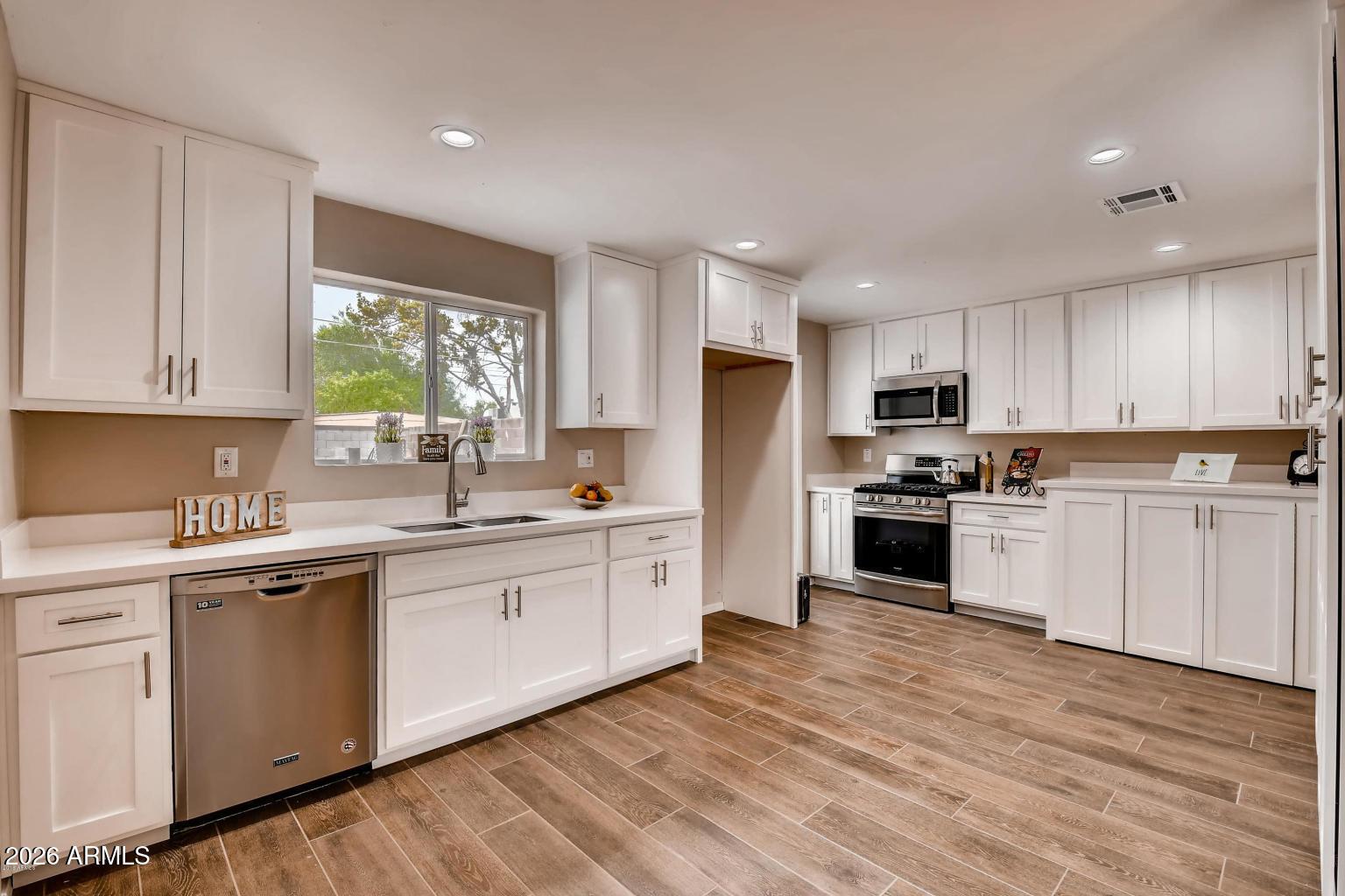 1806 East Don Carlos Tempe, AZ 85281 - Photo 4 of 14 a kitchen with white cabinets stainless steel appliances and window