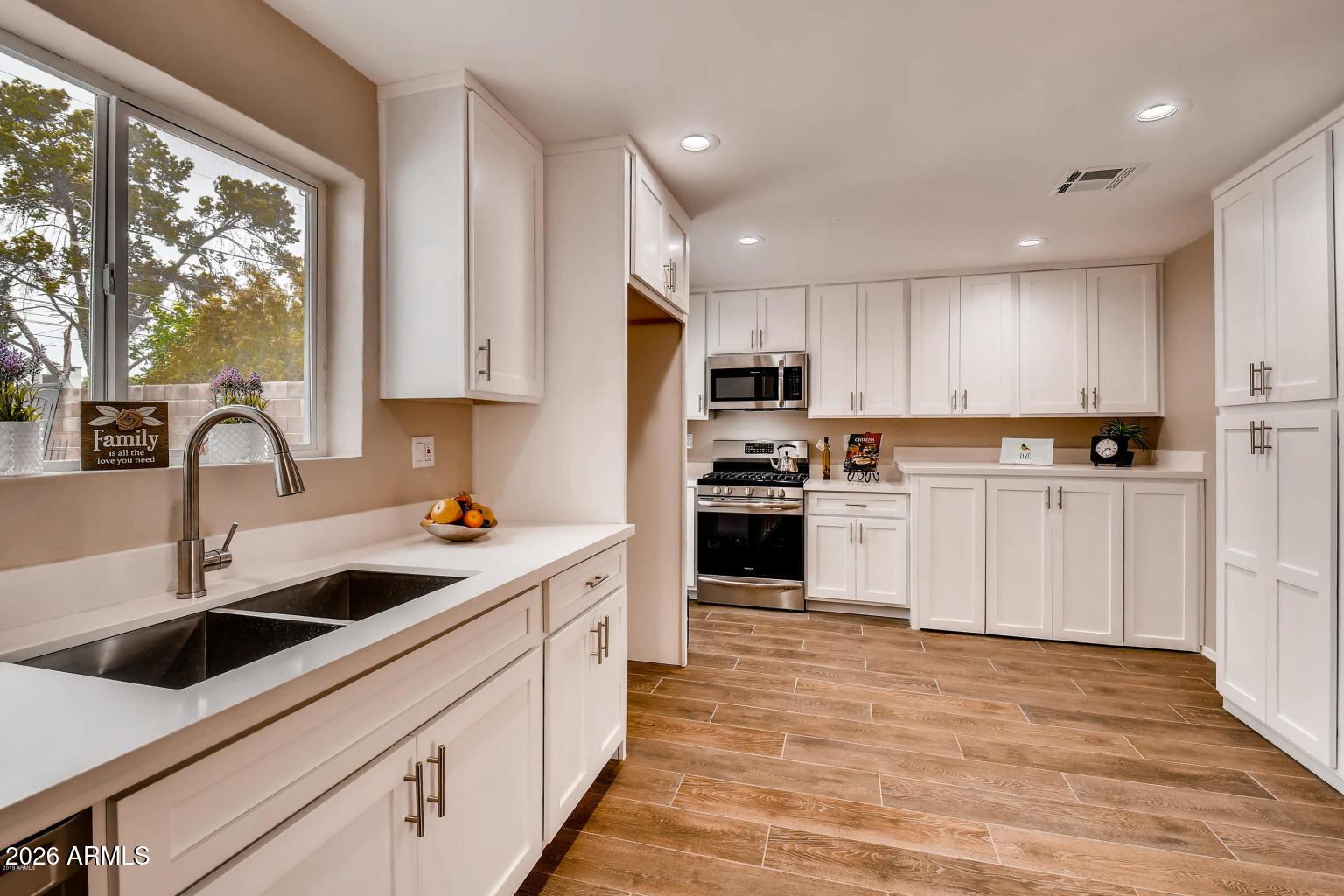 1806 East Don Carlos Tempe, AZ 85281 - Photo 5 of 14 a kitchen with kitchen island granite countertop a sink stainless steel appliances and window