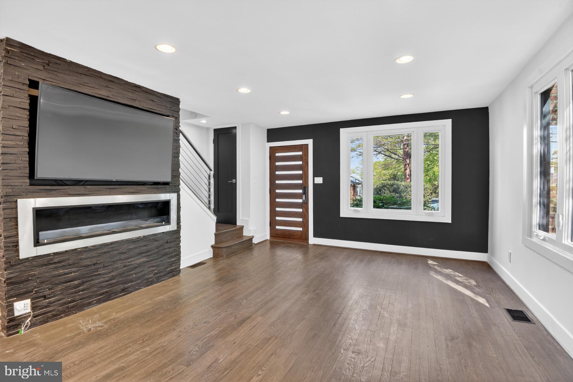 4416 Reno Road Northwest Washington, DC 20008 - Photo 12 of 39 an empty room with wooden floor fireplace and windows