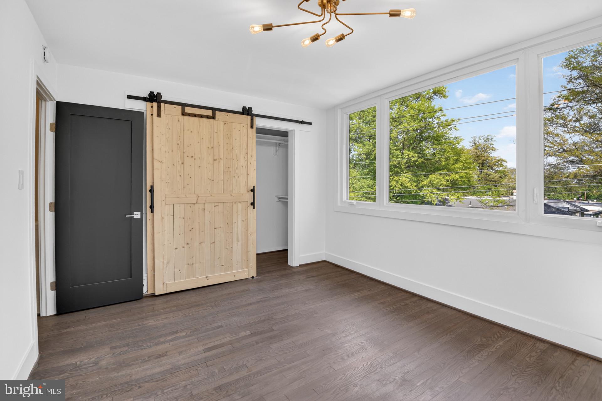 4416 Reno Road Northwest Washington, DC 20008 - Photo 14 of 39 an empty room with wooden floor fan and windows