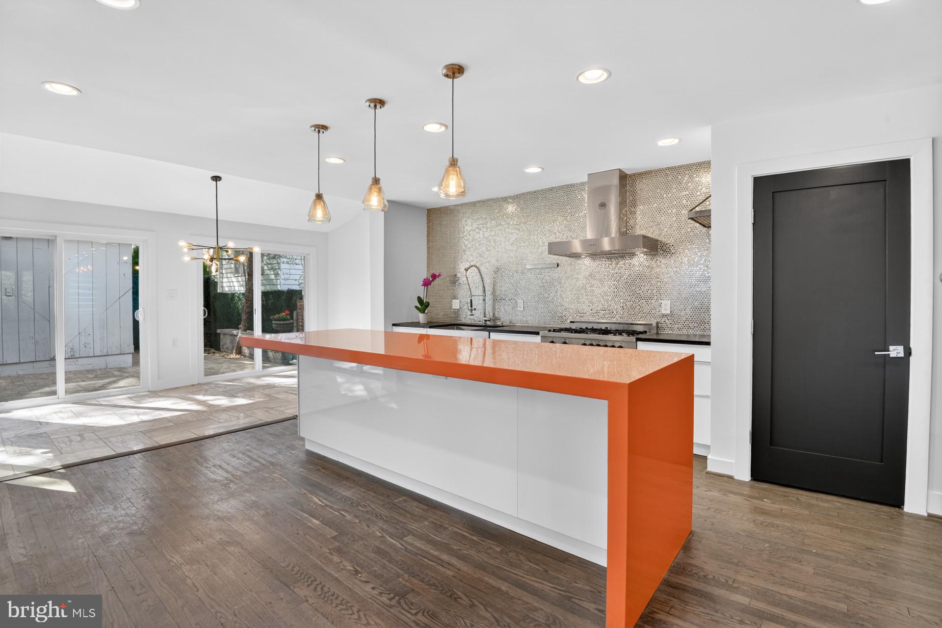 4416 Reno Road Northwest Washington, DC 20008 - Photo 5 of 39 a large kitchen with stainless steel appliances kitchen island a large counter top and a wooden floors