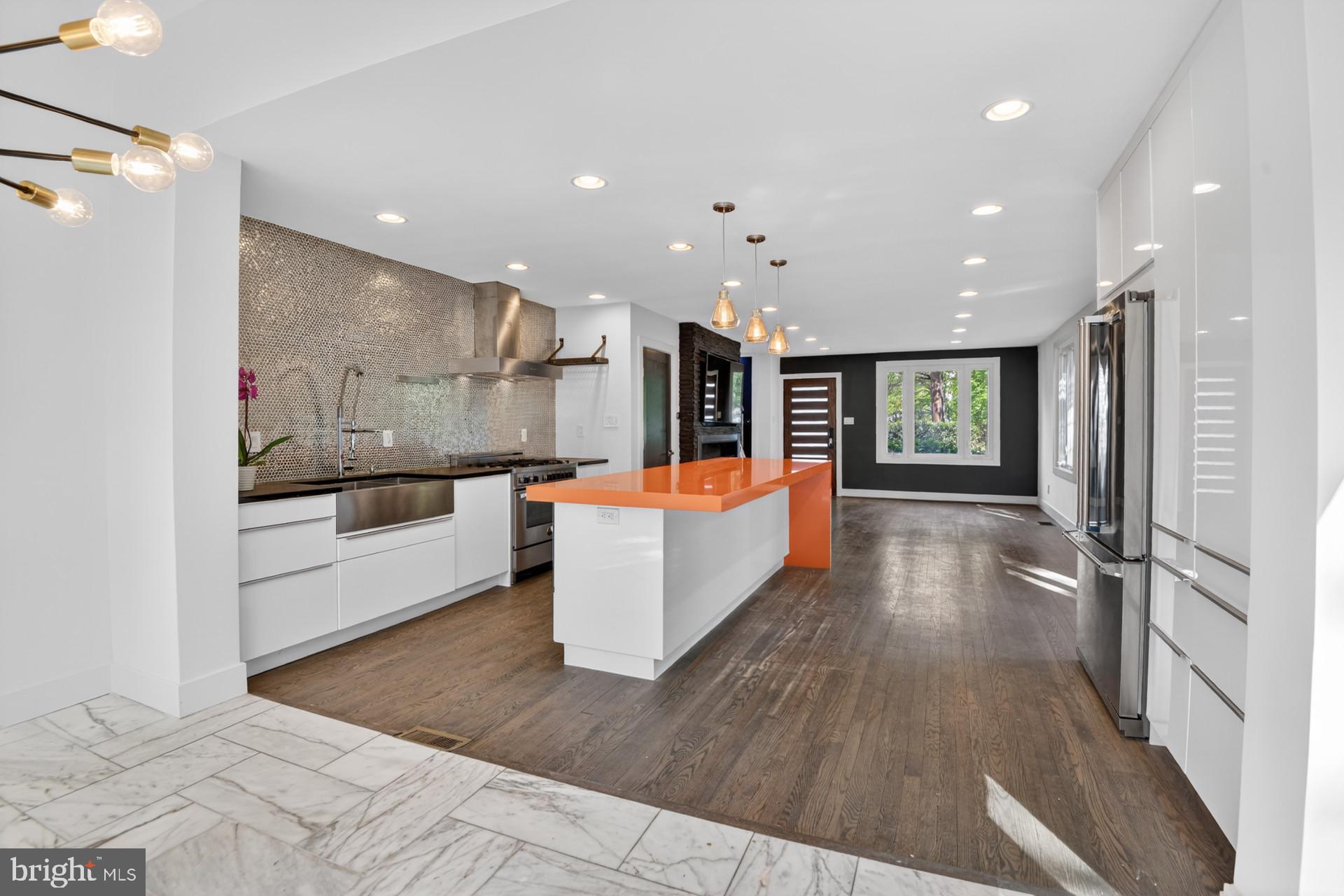 4416 Reno Road Northwest Washington, DC 20008 - Photo 7 of 39 a large kitchen with stainless steel appliances kitchen island a large counter top and a wooden floors
