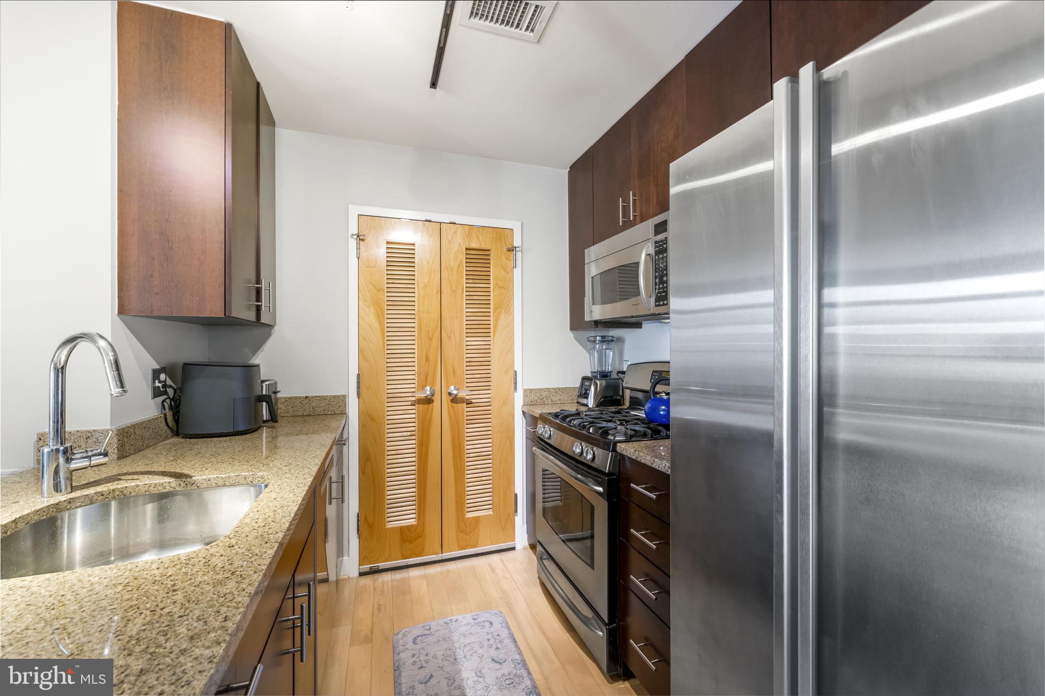 1529 14th Street Northwest, Unit 309 Washington, DC 20005 - Photo 7 of 21 a kitchen with stainless steel appliances granite countertop a refrigerator and a sink