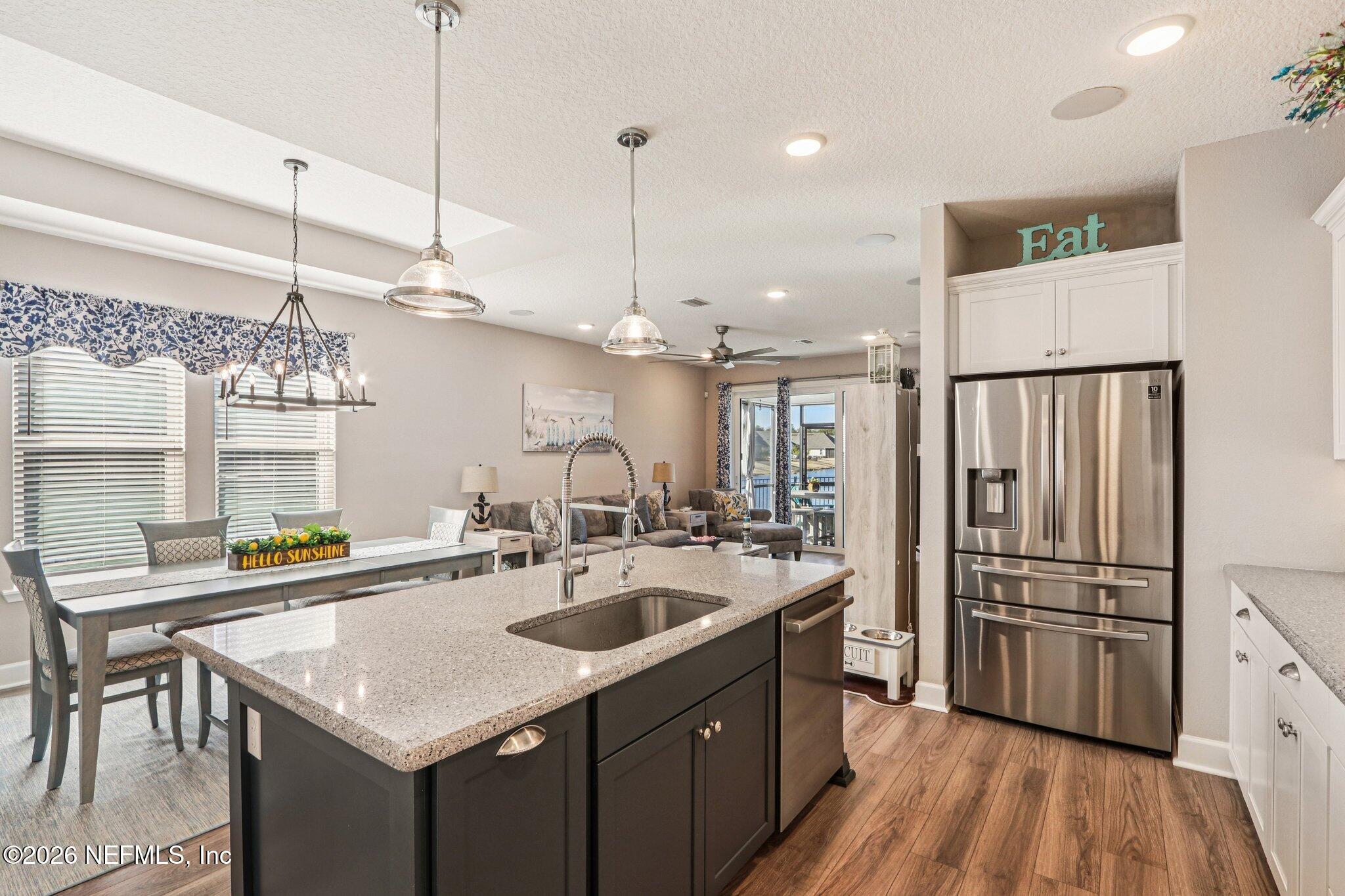 73 Andesite Trail Ponte Vedra, FL 32081 - Photo 12 of 42 a kitchen with stainless steel appliances granite countertop a sink a stove a refrigerator and island with wooden floor