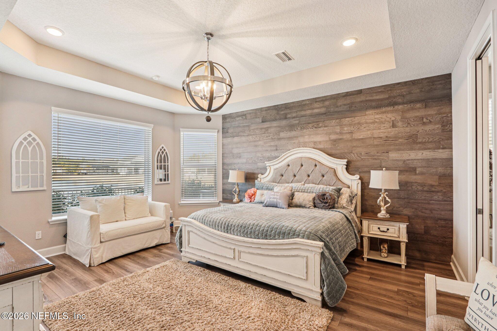 73 Andesite Trail Ponte Vedra, FL 32081 - Photo 15 of 42 a spacious bedroom with a bed a chandelier and a large window