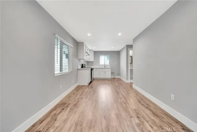 a view of empty room with wooden floor and window