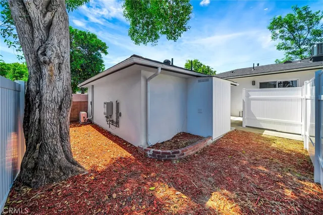 a view of a house with a small yard and a large tree