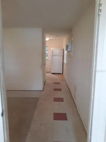 a view of a hallway with a refrigerator