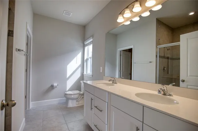 a bathroom with a double vanity sink mirror and toilet