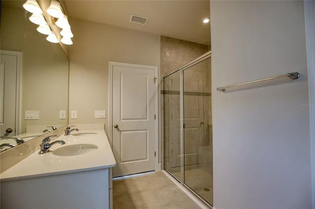 a bathroom with a sink shower and a mirror