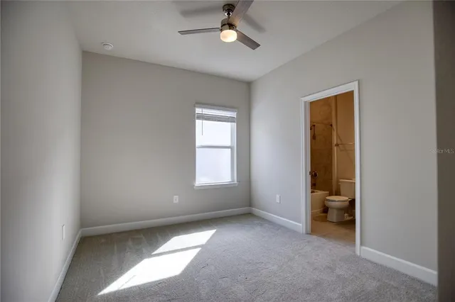 an empty room with closet and a chandelier fan