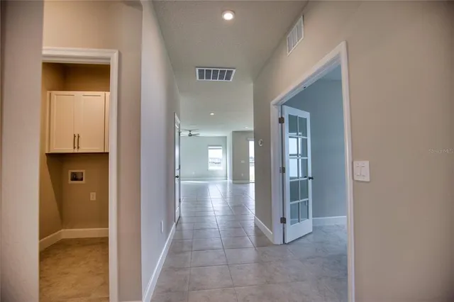 a view of a hallway with wooden shelves