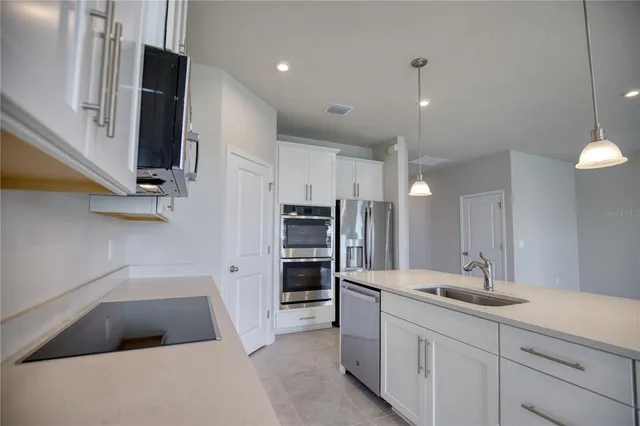 a large kitchen with a sink and dishwasher a oven with wooden floor