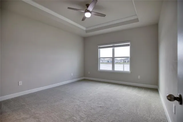 an empty room with a window and a ceiling fan