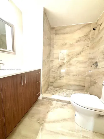 a bathroom with a toilet and a shower