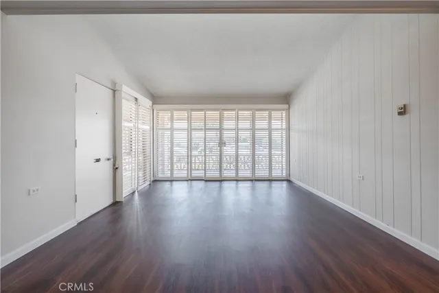 an empty room with wooden floor and white walls