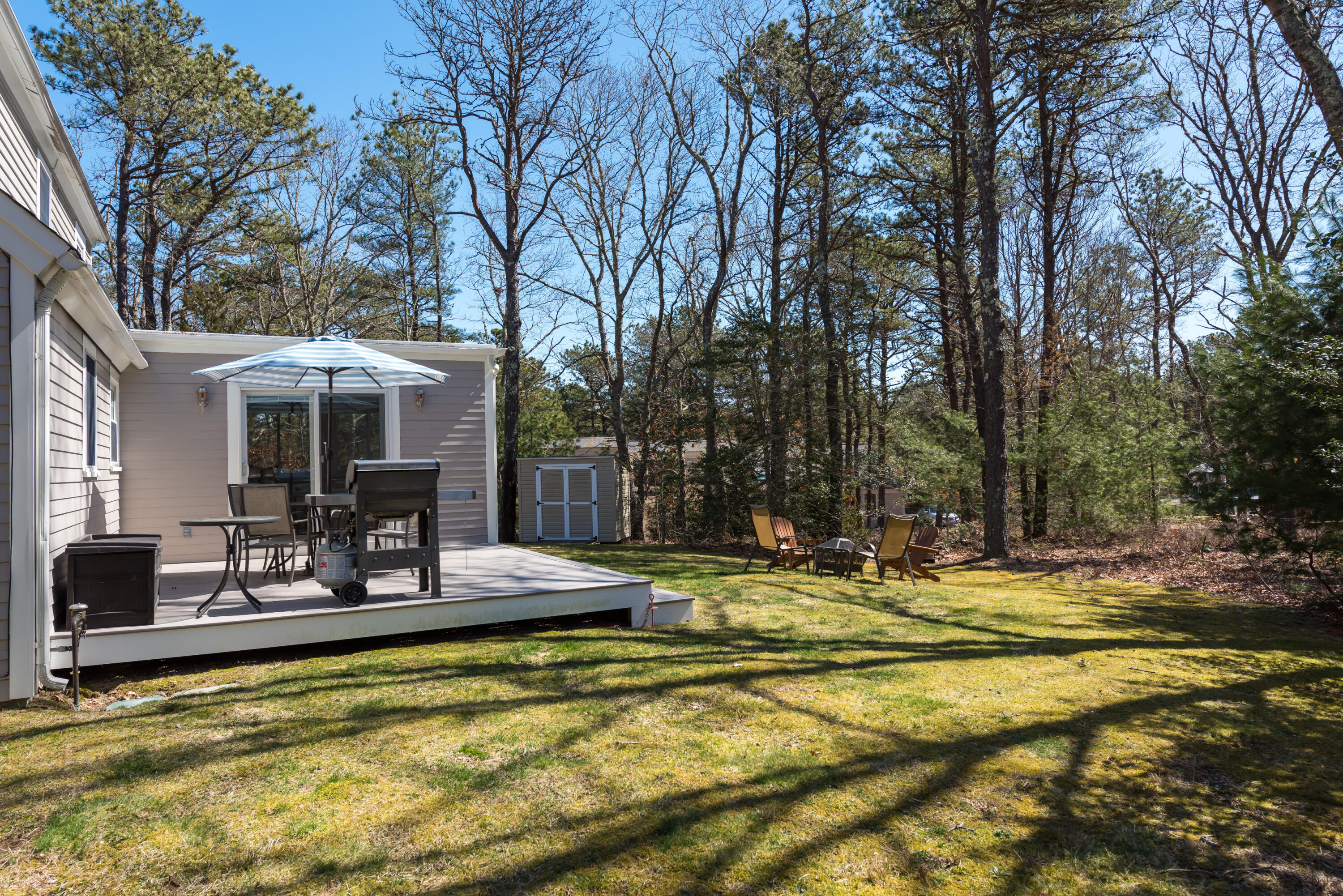 5 Amos Landing Road Mashpee, MA 02649 - Photo 5 of 27 a view of a swimming pool with chairs and table in front of house