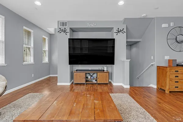 a kitchen with a stove a refrigerator a oven and a sink with wooden floor