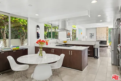 a dining room with wooden floor a chandelier a wooden table and chairs