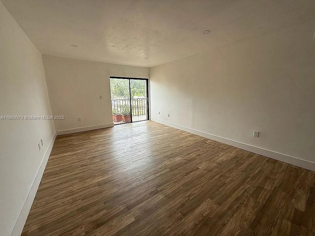 1800 West 54th Street, Unit 105 Hialeah, FL 33012 - Photo 26 of 59 wooden floor in an empty room with a window