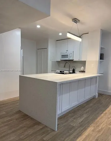 a kitchen with kitchen island cabinets and wooden floor