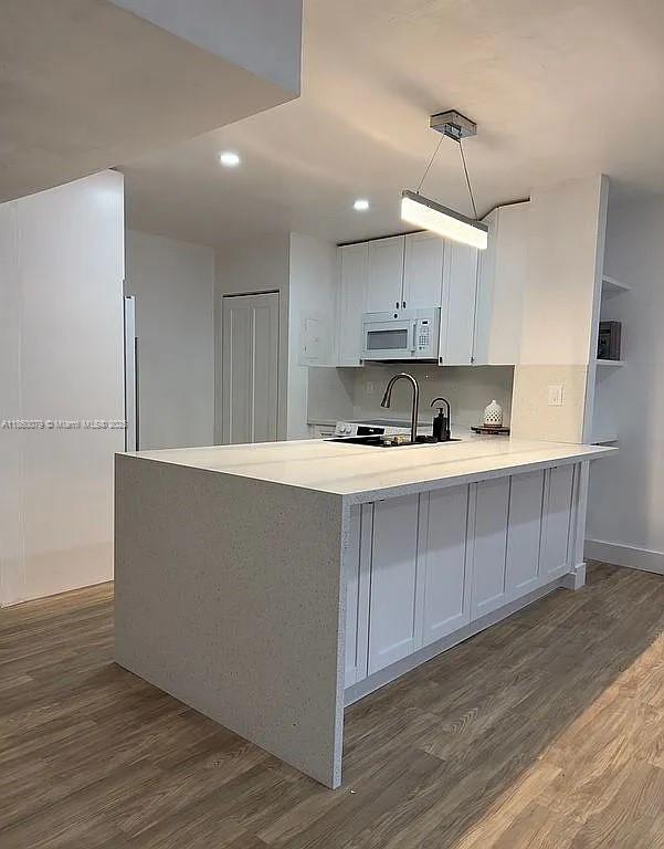 1800 West 54th Street, Unit 105 Hialeah, FL 33012 - Photo 3 of 59 a kitchen with kitchen island cabinets and wooden floor