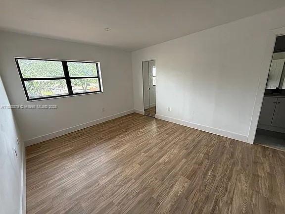 1800 West 54th Street, Unit 105 Hialeah, FL 33012 - Photo 31 of 59 an empty room with wooden floor and windows