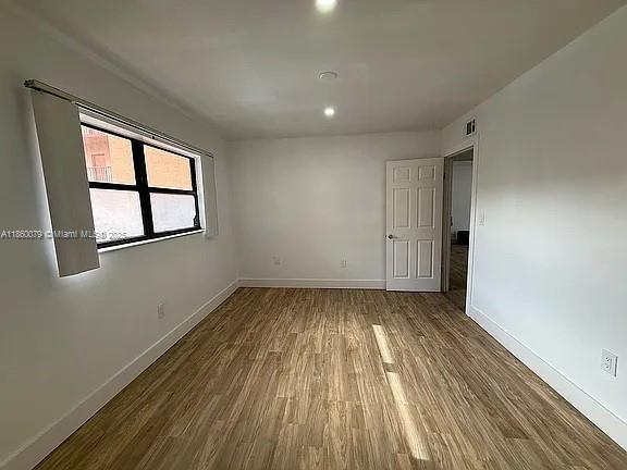 1800 West 54th Street, Unit 105 Hialeah, FL 33012 - Photo 39 of 59 an empty room with wooden floor and windows
