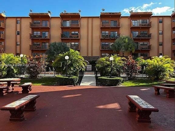 1800 West 54th Street, Unit 105 Hialeah, FL 33012 - Photo 49 of 59 a view of a brick building with plants and bench in front of it
