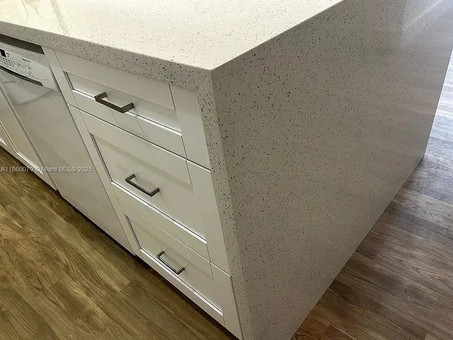 a kitchen with a sink cabinets stainless steel appliances and a window