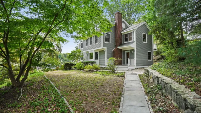 a front view of a house with yard and green space