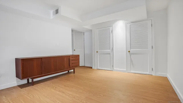a view of an empty room with wooden floor