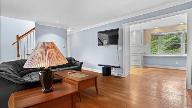 a kitchen with a white appliances wooden floor and a large window