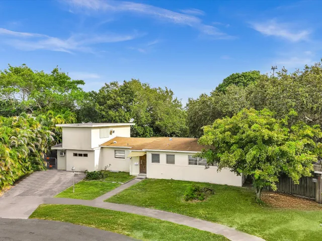 an aerial view of a house with garden space and a lake view