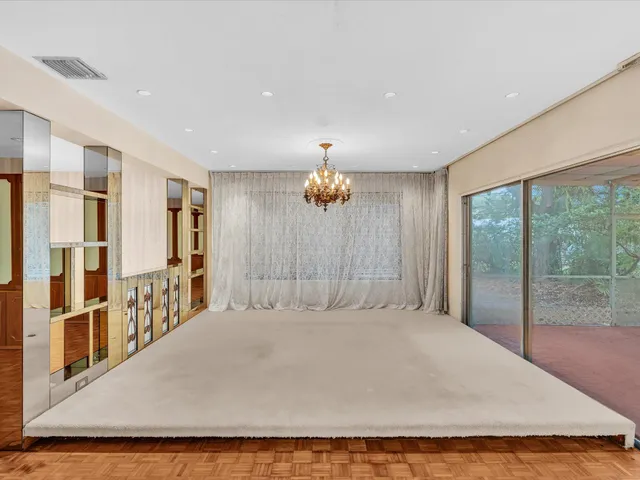 a bedroom with a large bed and a chandelier