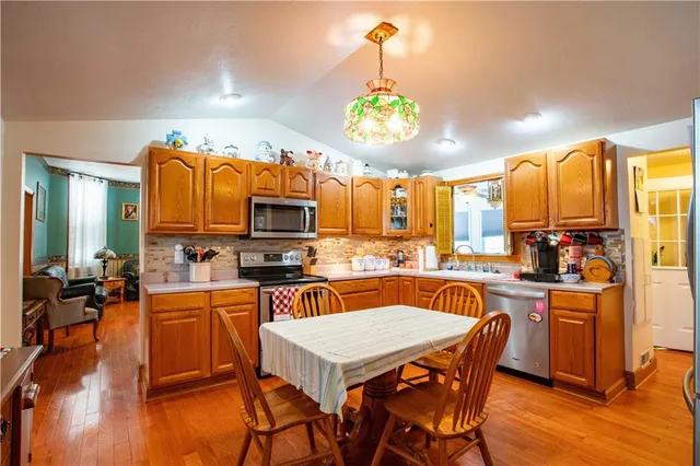 a kitchen with a table chairs refrigerator and microwave