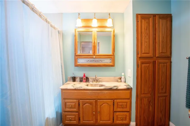 a bathroom with a granite countertop sink and a mirror