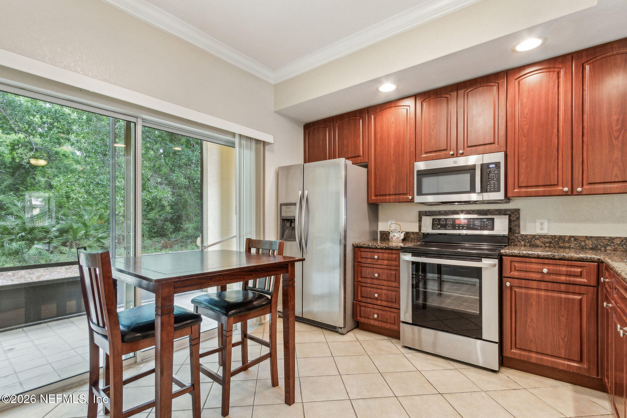 9745 Touchton Road, Unit 1205 Jacksonville, FL 32246 - Photo 6 of 20 a kitchen with stainless steel appliances granite countertop a stove microwave and refrigerator