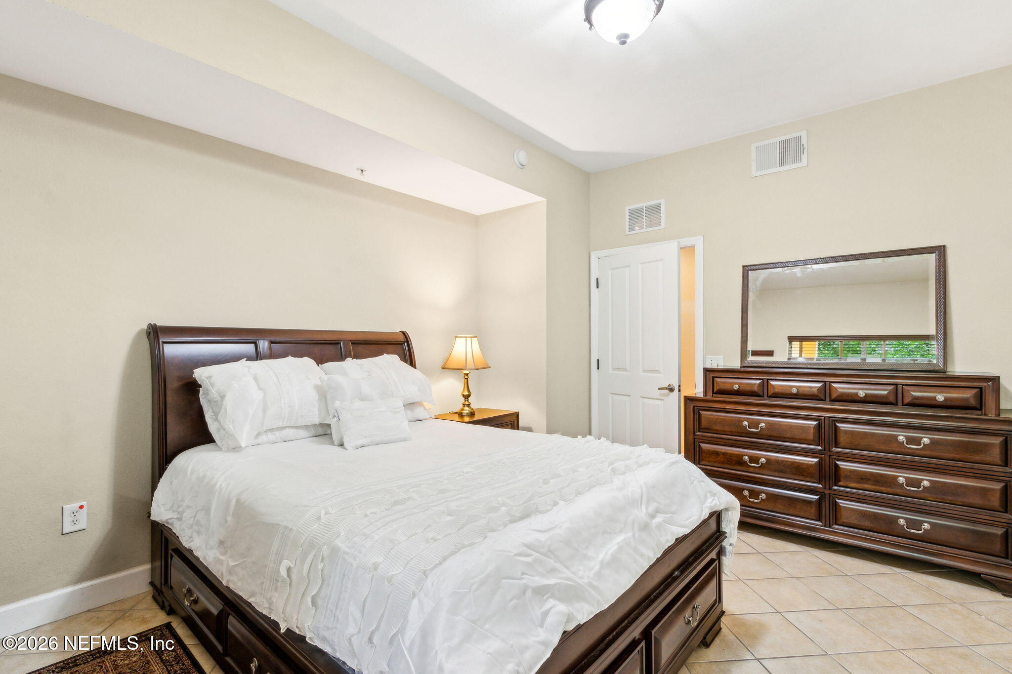 9745 Touchton Road, Unit 1205 Jacksonville, FL 32246 - Photo 9 of 20 a bedroom with a bed and a flat tv screen on dresser