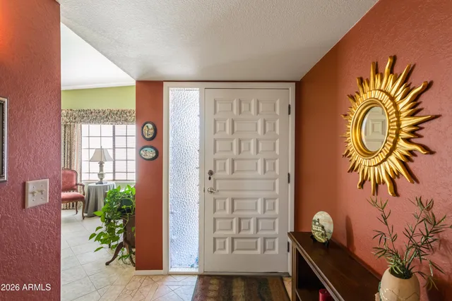 an entryway with a potted plant and wooden floor