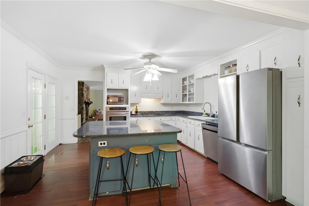311 Cumberland Way Anderson, SC 29621 - Photo 10 of 44 A well-lit kitchen with dark wood floors and a granite island with seating offers a perfect culinary space.