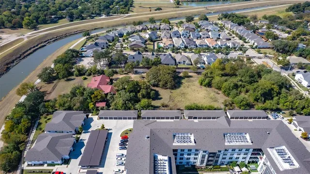 an aerial view of residential houses with outdoor space and trees